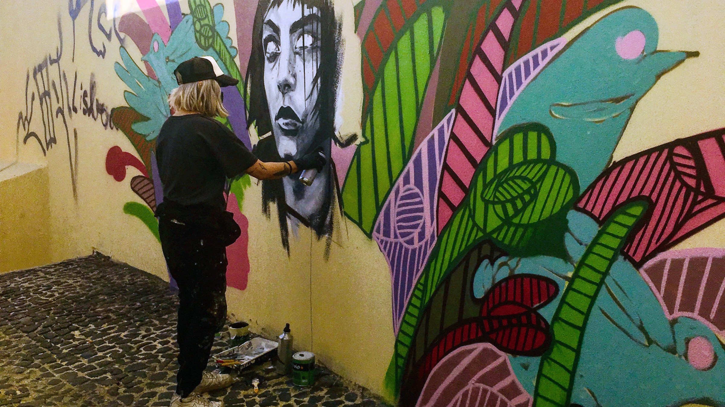 Street artist painting on a Lisbon wall