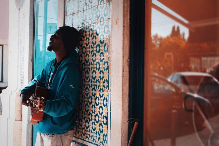 a man standing in front of a window playing an instrument in Lisbon