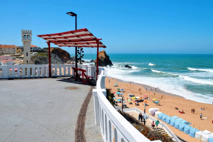 A group of people on a sandy beach next to the ocean in Porto