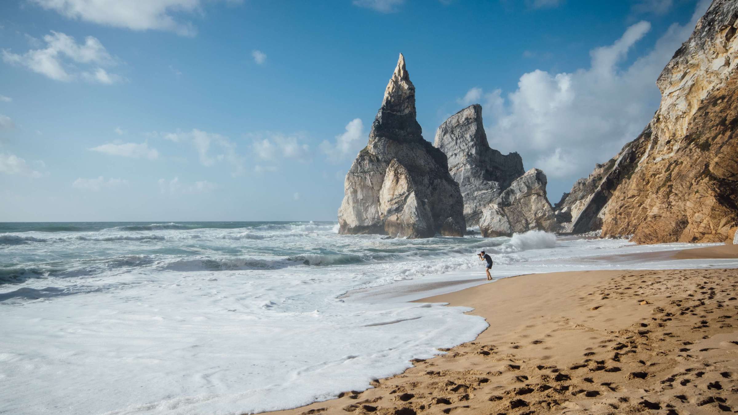 person by the Ursa beach with the sea and rocks in Portugal