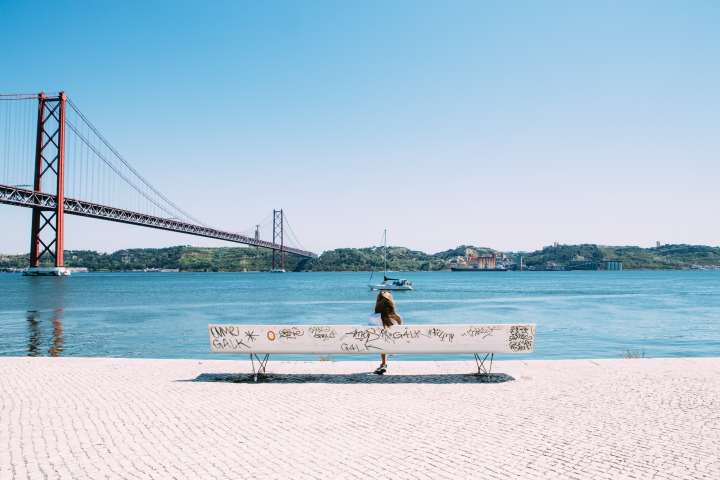 A woman on a bench by water in Lison