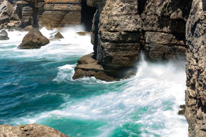 Waves and boulders by Cascais beach in Portugal