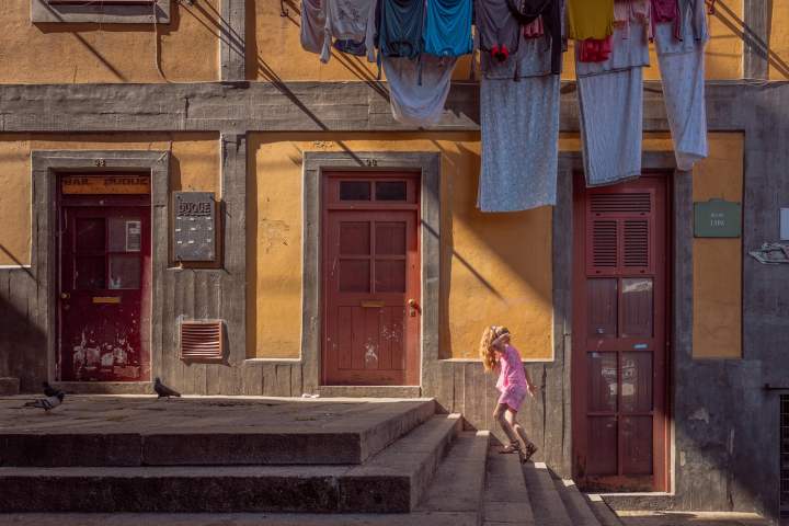 a person walking down a street in front of a building